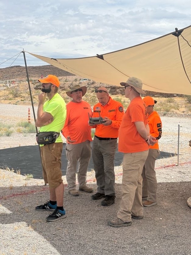 A SAR team in the field gathered around a drone controller